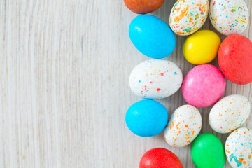 Fototapeta na wymiar Easter candy eggs on white wooden surfae