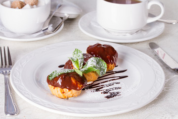 Profiteroles with chocolate sauce and mint leaf
