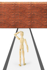 Man stands in front of the brick wall. Abstract image with a wooden puppet