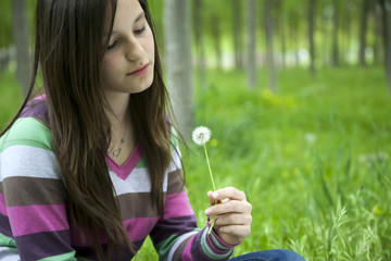 Young women blowing dandelion