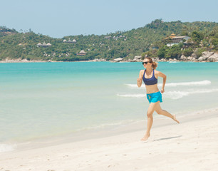Fototapeta na wymiar Sports girl runs along the beach. Healthy lifestyle concept, wel
