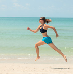 Sports girl runs along the beach. Healthy lifestyle concept, wel