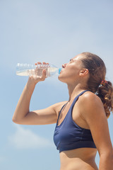 Cute girl drinks water after training