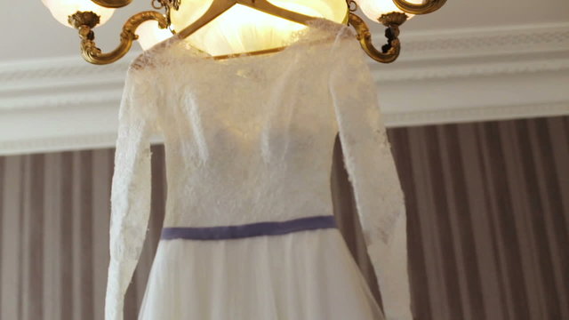 Elegant wedding dress on a hanger specially made for a wedding ceremony of a young bride.