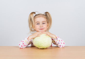 Fototapeta premium Little girl holding forks of cabbage.