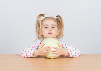 Fototapeta premium Little girl holding forks of cabbage.