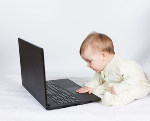 Cute baby boy with black laptop