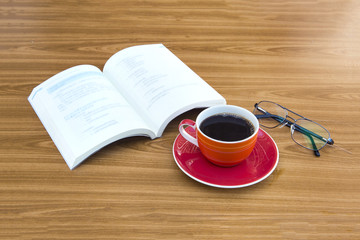 Cup of coffee with book and glasses