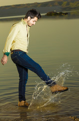 Caucasian boy playing with water splash in Iraqi countryside