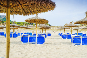 Umbrellas and sunbeds on the beach Cala Mesquida. Majorca. Balearic Islands. Spain