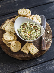 Healthy vegetarian broccoli and pine nuts hummus and homemade cheese biscuits on a wooden rustic board. Delicious snack or appetizer with wine