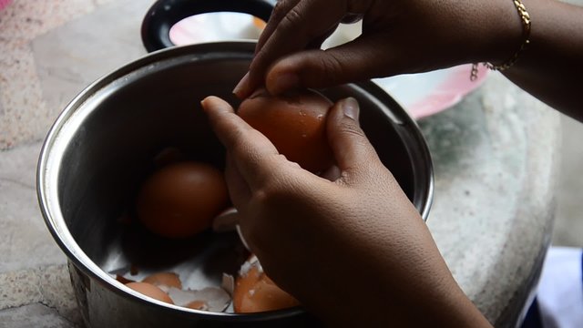 Thai woman peeling boiled egg for cooking Pork stewed in the gravy brown sauce