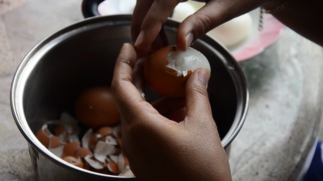 Thai woman peeling boiled egg for cooking Pork stewed in the gravy brown sauce