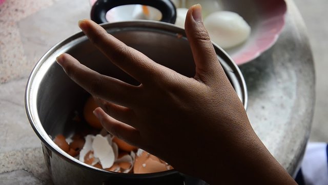 Thai woman peeling boiled egg for cooking Pork stewed in the gravy brown sauce
