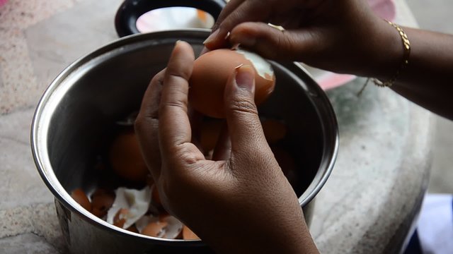 Thai woman peeling boiled egg for cooking Pork stewed in the gravy brown sauce