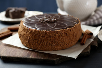 Tasty chocolate cake on color wooden background