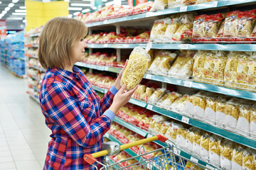 Woman with package pasta in shop