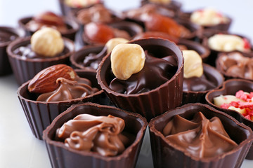 Delicious chocolate candies on white background, close up