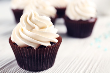 White cupcakes on wooden table