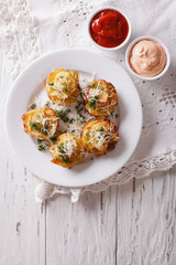 Sliced baked potato with cheese and sauce on the table. vertical top view

