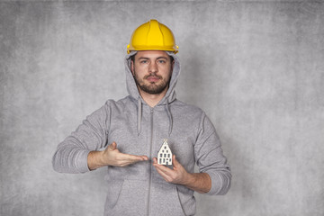 Worker holds a house in his hand