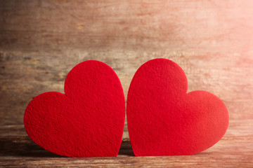 Red felt hearts on wooden background
