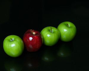 Red and green apple fruit isolated on black background in row