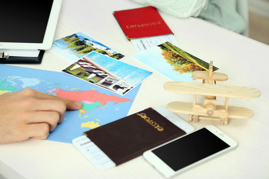 Passports with tickets, photos and world map at the table in office of the travel company