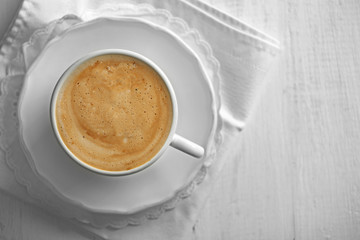 Cup of coffee with foam on wooden background