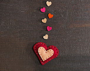 Valentine concept. Felt heart with small hearts on wooden background