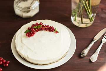 yoghurt cake with currants on wooden background