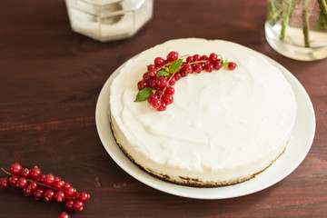 yoghurt cake with currants on wooden background