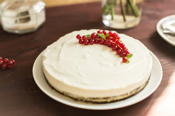yoghurt cake with currants on wooden background