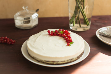 yoghurt cake with currants on wooden background