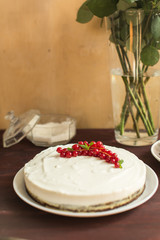 yoghurt cake with currants on wooden background