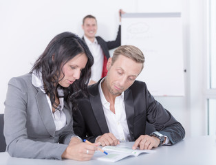 Kollegin und Kollege besprechen sich in einem Seminar