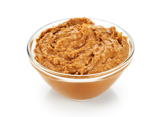 Bowl with peanut butter isolated on white background.