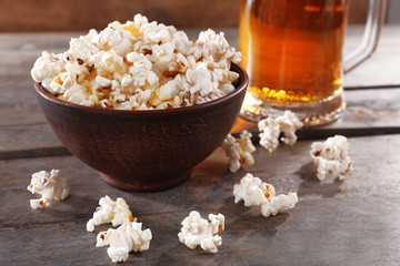 Glass mug of light beer with popcorn on wooden table, close up - obrazy, fototapety, plakaty
