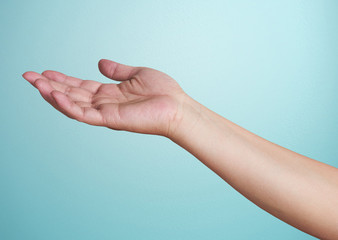 Close-up of  hand isolated on blue background. Palm up