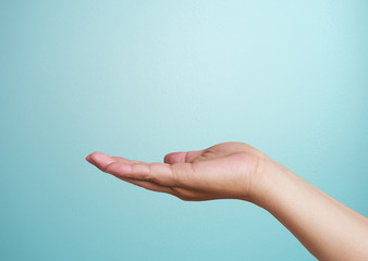 Close-up of  hand isolated on blue background. Palm up