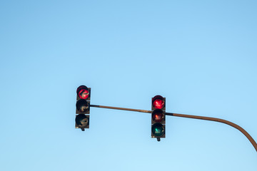 traffic lights showing red to all directions against a blue sky