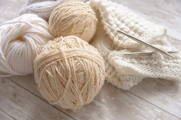 Fototapeta na wymiar white and beige balls of yarn and knitting needles