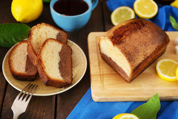 Delicious sweet cake bread with lemons on wooden table closeup