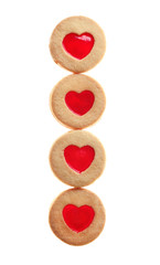 Tasty cookies with heart shape jam filling in a row isolated on white background