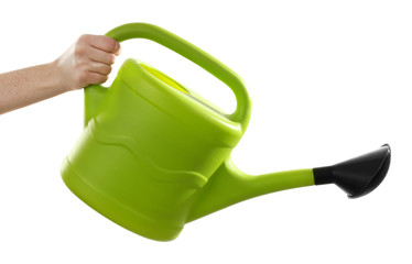 Female hand holding a simple green plastic watering can with black spout isolated on white...