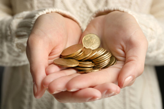Female hands holding a handful of Ukrainian coins, close up