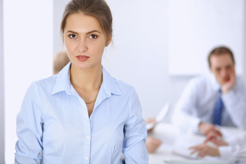 Fototapeta premium Beautiful business woman on the background of business people during meeting