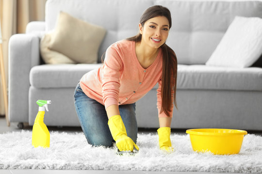 Beautiful Woman In Protective Gloves Cleaning Carpet With Brush And Spray