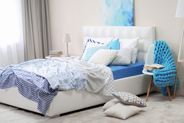 Bedroom interior in light tones with white furniture and pillows