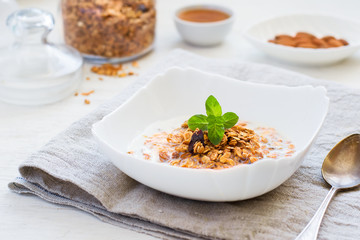 Granola with milk, honey and nuts on a white background. healthy